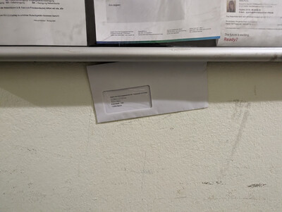 Bild öffnet in neuem Tab/Fenster ein an einen Glaskasten geklemmter Brief